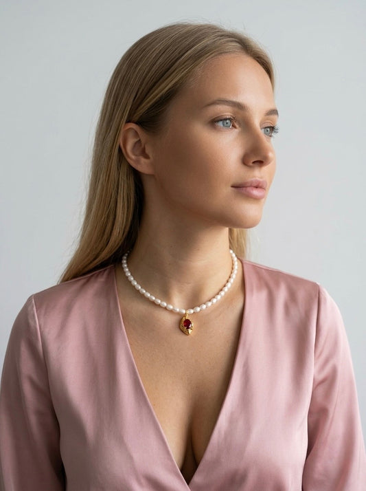 Dabīgo upes pērļu kaklarota ar apzeltītu kulonu un sarkanu kristālu. Ameno.lv rotaslietas