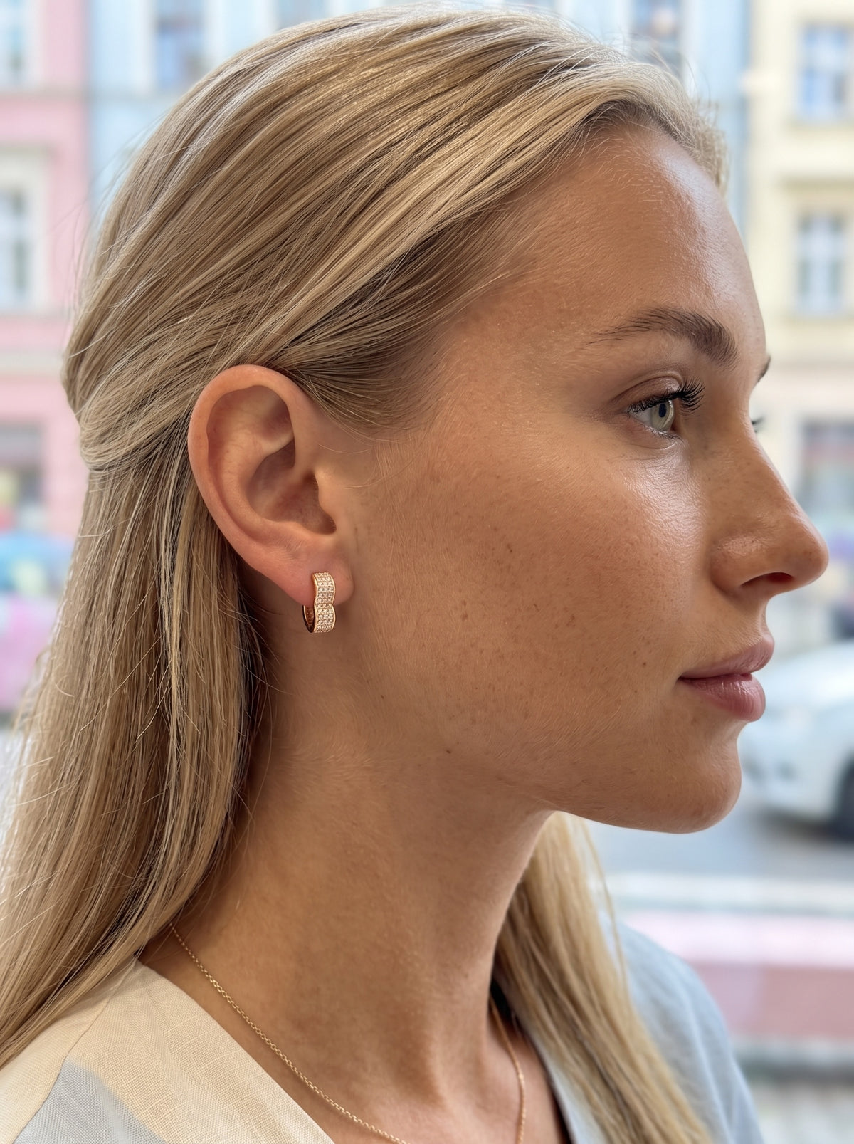 Sieviete ar 18K apzeltītiem auskariem "Tendresse" modernā sirds formā.